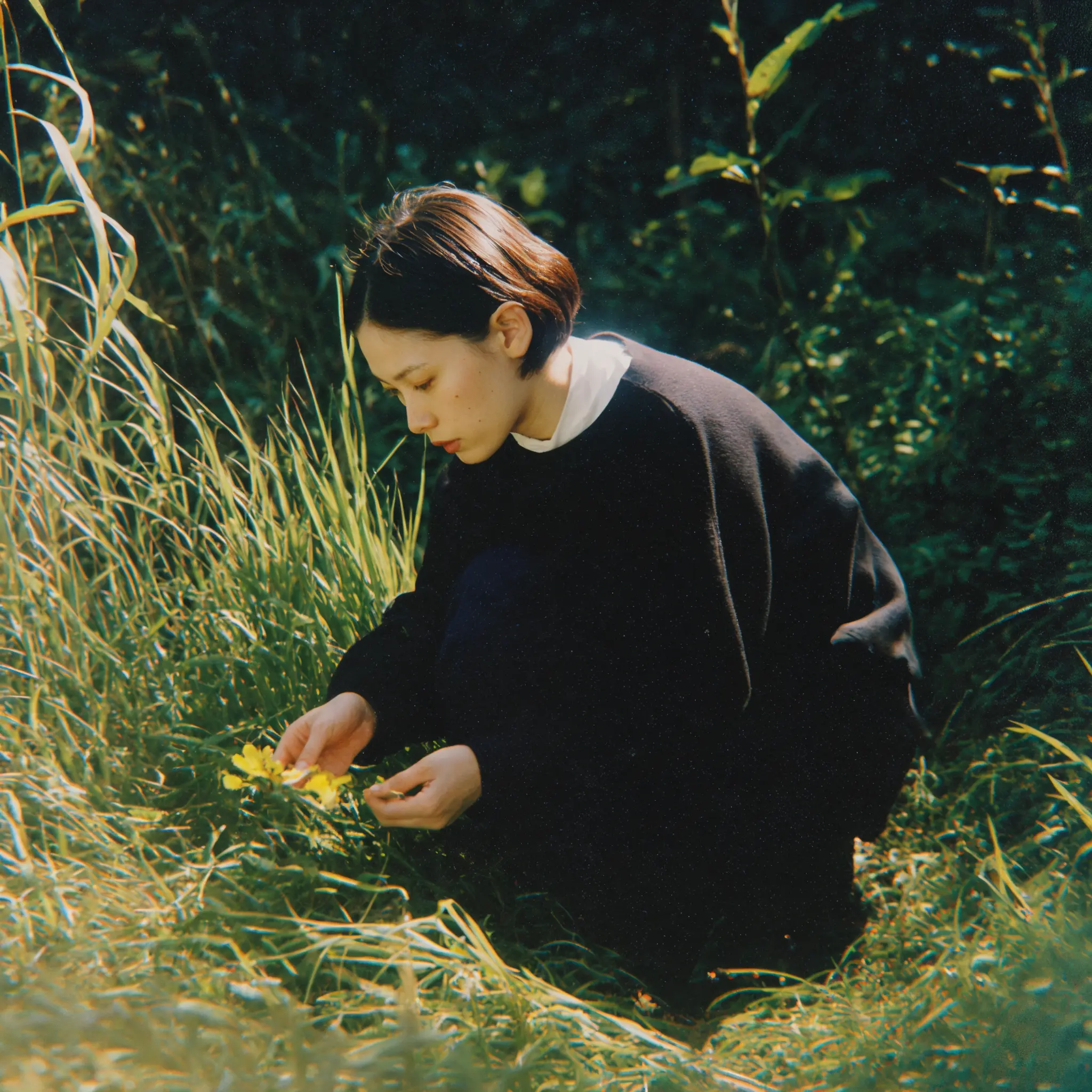 frau sitzt glücklich auf einer wiese